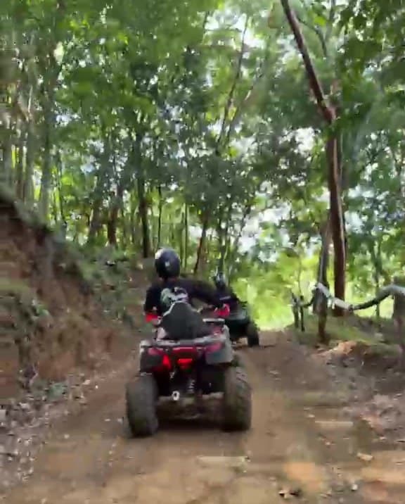 Una cuatrimoto subiendo por el camino de selva lleno de surcos, vista desde el quad que va detrás