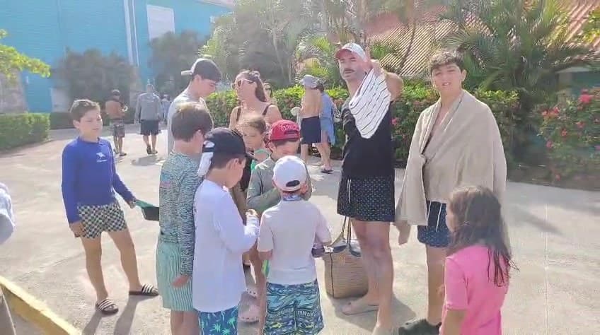 A family group gathered with their towels and bags at the meeting point outside the port